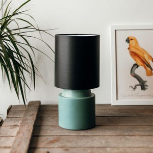 Round modern green matte stoneware ceramic bedside table lamp with black fabric shade