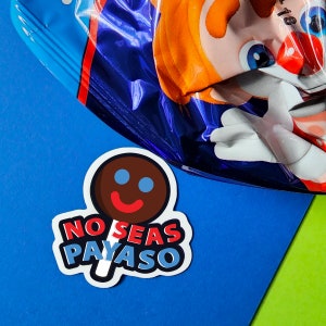 May include: A sticker with a brown lollipop with a smiling face and the text "NO SEAS PAYASO" in red, blue, and white.