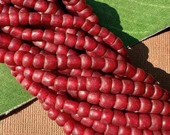 May include: Close-up of a strand of red glass beads. The beads are small, cylindrical, and have a slightly translucent appearance. The beads are strung together, forming a dense, textured surface. The text "JT3101" is visible in the upper right corner.