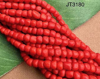 May include: Close-up of strands of bright red beads. The beads are small, rectangular, and strung together. The image includes the text "JT3180" in the upper right corner. The beads are displayed against a green and tan background.
