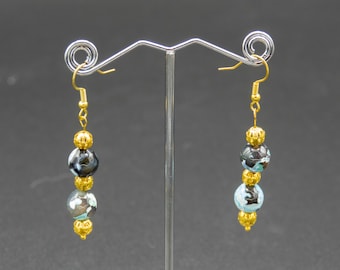 May include: A pair of dangle earrings with three beads each. The beads are black, blue, and white agate with gold accents.