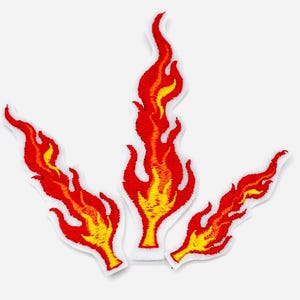 Könnte beinhalten: Drei gestickte Flammenaufnäher in Rot und Gelb. Jeder Aufnäher zeigt ein stilisiertes Flammendesign mit weißem Rand. Die Flammen haben einen lebendigen Farbverlauf, der von Gelb an der Basis zu Rot an den Spitzen übergeht.