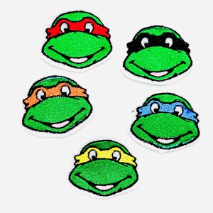 Könnte beinhalten: Fünf gestickte Aufnäher mit den Teenage Mutant Ninja Turtles. Jeder Aufnäher zeigt das Gesicht einer Schildkröte mit einer andersfarbigen Maske: rot, schwarz, orange, blau und gelb. Die Aufnäher sind grün mit weißen Rändern.