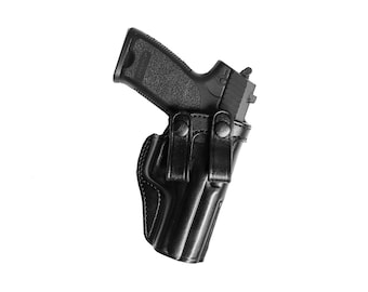 Op de afbeelding: Een zwart leren holster met een zwart pistool erin. Het holster heeft twee verstelbare banden en een drukknopsluiting.