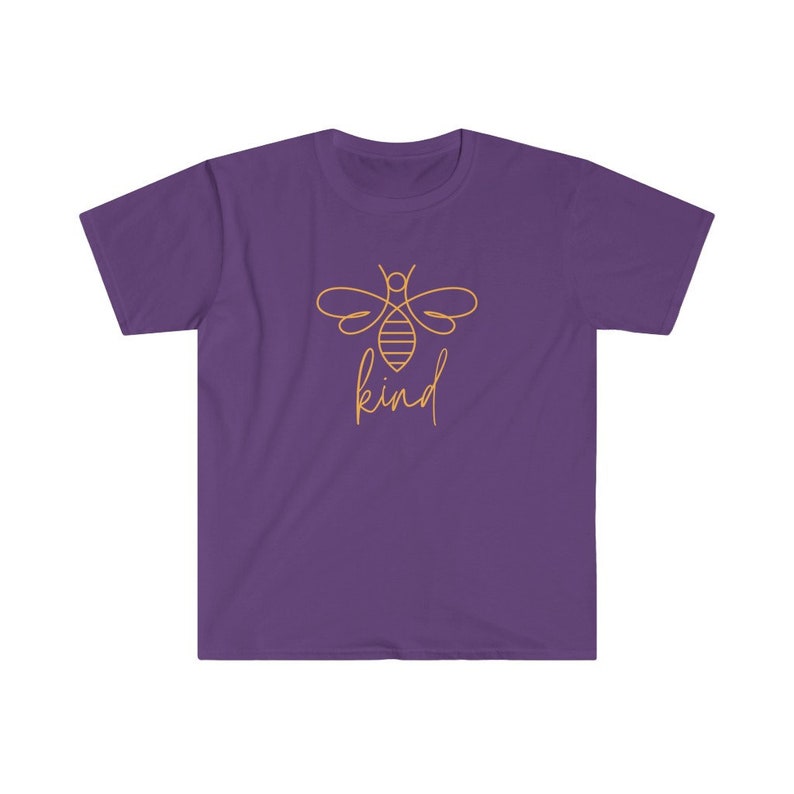 Puede incluir: Camiseta morada con un contorno dorado de una abeja y la palabra "kind" en cursiva. El dise&ntilde;o de la abeja est&aacute; centrado en la parte delantera de la camiseta. La camiseta tiene mangas cortas y cuello redondo.
