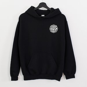 Peut inclure: Sweat-shirt &agrave; capuche noir avec un embl&egrave;me de pompier blanc sur le devant. L'embl&egrave;me repr&eacute;sente une croix avec une hache, une &eacute;chelle et les mots "Fire Dept."