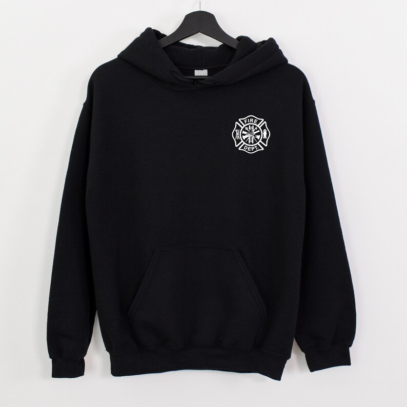 Peut inclure: Sweat-shirt &agrave; capuche noir avec un embl&egrave;me de pompier blanc sur le devant. L'embl&egrave;me repr&eacute;sente une croix avec une hache, une &eacute;chelle et les mots "Fire Dept."