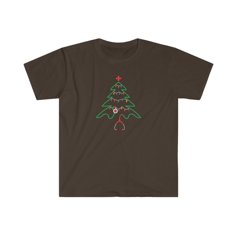 以下が含まれることがあります： 暗い茶色のTシャツに緑色のクリスマスツリーのデザインが施されています。ツリーは赤と白のオーナメント、赤い十字架、聴診器で飾られています。