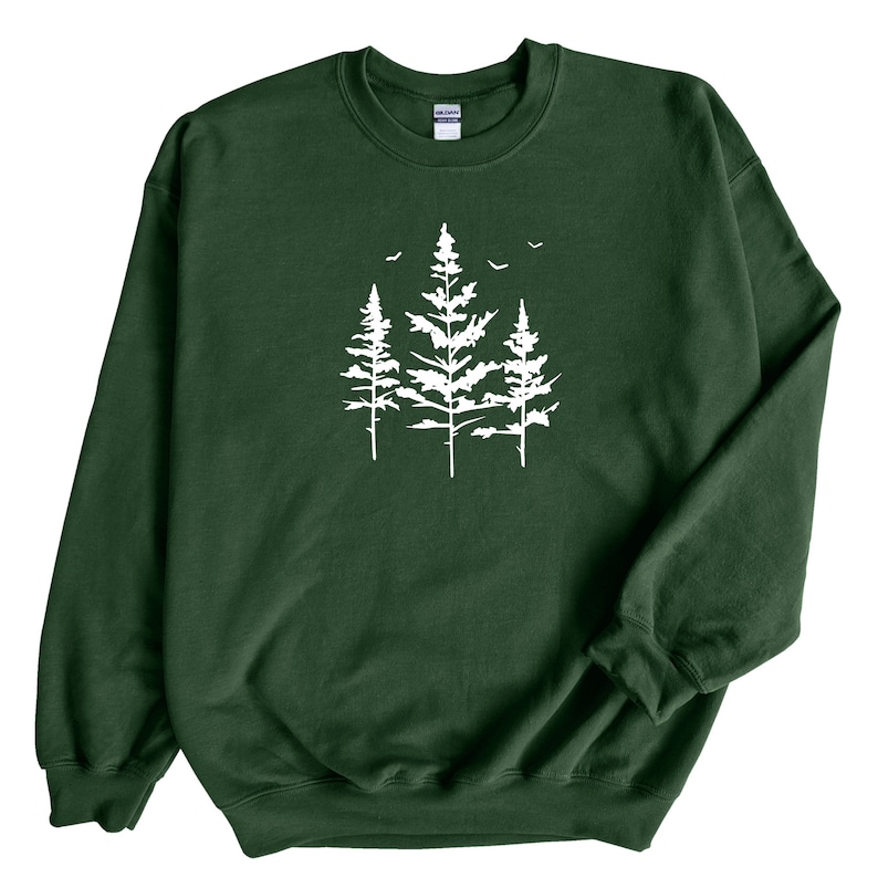 May include: A dark green sweatshirt featuring a white silhouette of three pine trees with birds flying above them.