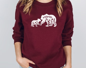 May include: Burgundy sweatshirt with a white silhouette of two bears, one larger than the other. The larger bear has the word "mama" written on it. Both bears are surrounded by flowers and butterflies.