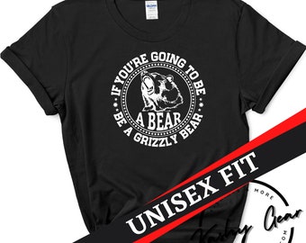 May include: Black t-shirt with a white circle graphic featuring a grizzly bear and the text "If you're going to be a bear, be a grizzly bear."