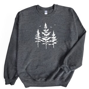 May include: A dark grey sweatshirt featuring a white silhouette of three pine trees with birds flying above them.