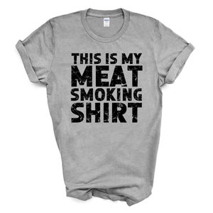 May include: A gray t-shirt with the text "This is my meat smoking shirt" printed in black.