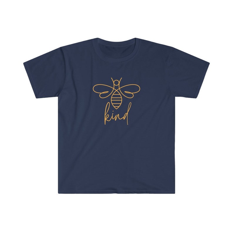 Puede incluir: Camiseta azul marino con un contorno dorado de una abeja y la palabra "kind" en escritura manuscrita. El dise&ntilde;o est&aacute; centrado en la parte delantera. La camiseta tiene mangas cortas y cuello redondo.