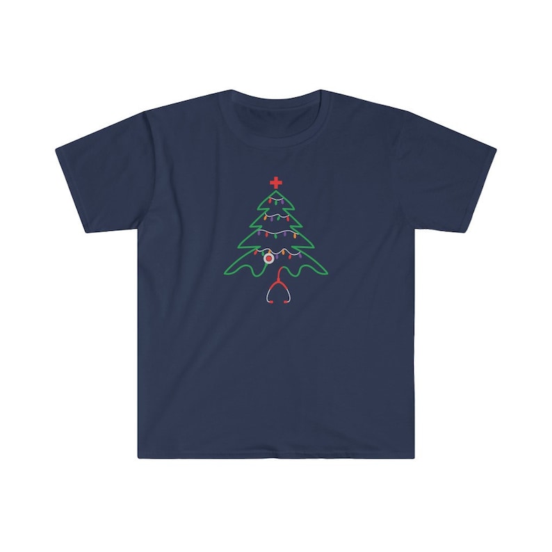 以下が含まれることがあります： 紺色のTシャツに緑色のクリスマスツリーのデザインが施されています。ツリーは赤と白のオーナメント、赤い十字架、聴診器で飾られています。