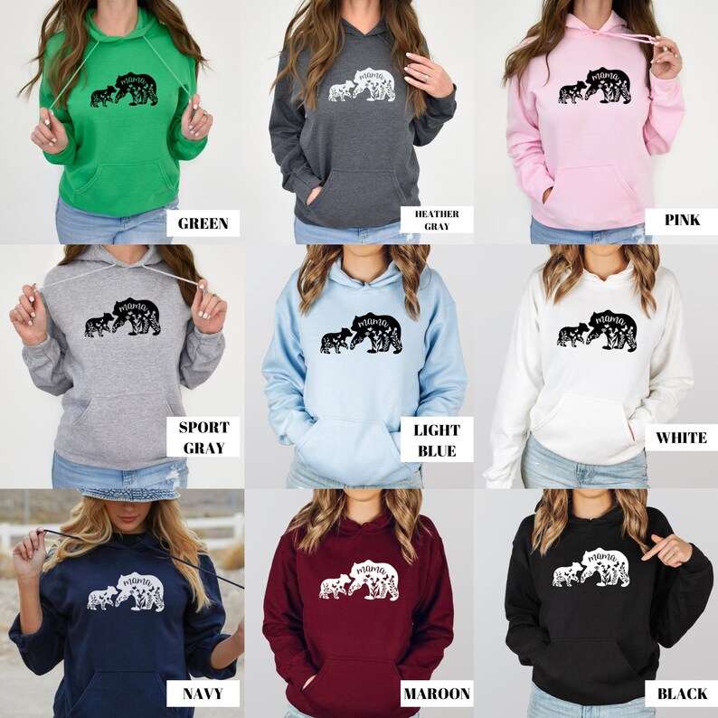 May include: A set of ten hooded sweatshirts in various colors, each featuring a black and white graphic of a mother bear and her cub with the word "mama" inside the bear's outline. The colors include green, heather gray, pink, sport gray, light blue, white, navy, maroon, and black.