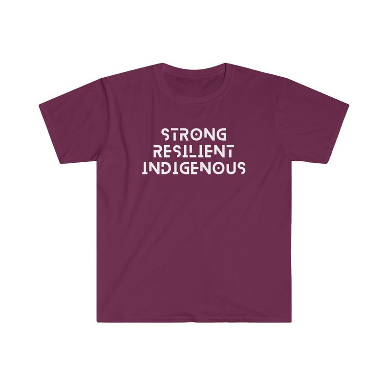 May include: A maroon t-shirt with the words "STRONG RESILIENT INDIGENOUS" printed in white on the front.