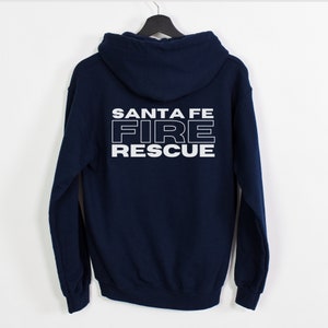 Peut inclure: Un sweat &agrave; capuche bleu marine avec les mots "SANTA FE FIRE RESCUE" imprim&eacute;s en blanc au dos.
