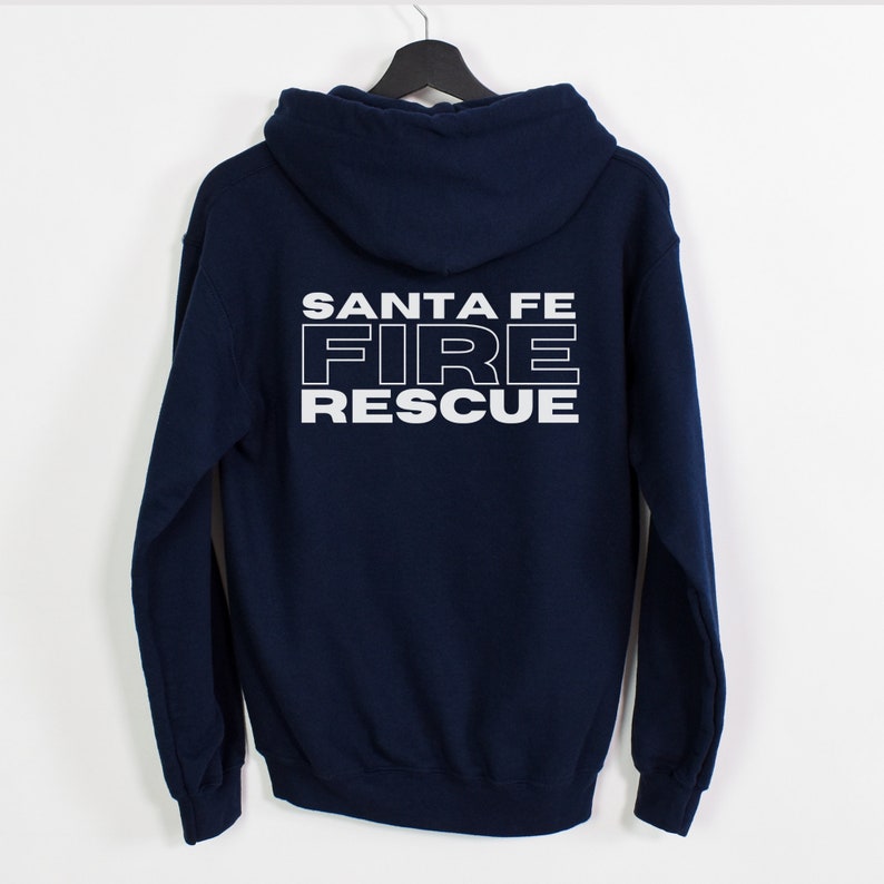 Peut inclure: Un sweat &agrave; capuche bleu marine avec les mots "SANTA FE FIRE RESCUE" imprim&eacute;s en blanc au dos.