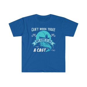 May include: A royal blue t-shirt with a graphic of a fisherman in a boat with the text "Can't work today, my arm is in a cast".