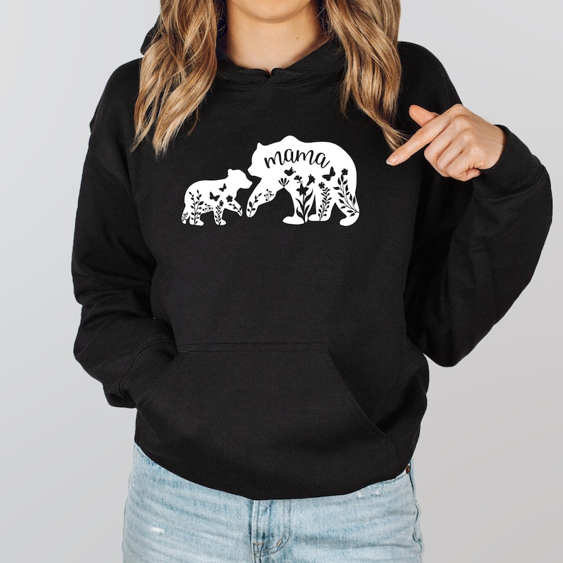 May include: Black hooded sweatshirt with a white silhouette of a mama bear and a baby bear with the word "mama" above them. The bears are surrounded by flowers and butterflies.