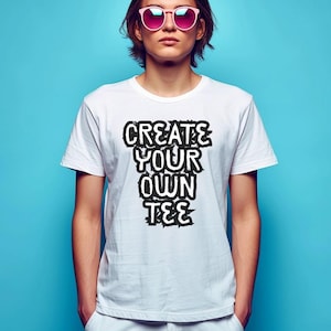 Peut inclure: T-shirt blanc avec le texte "CREATE YOUR OWN TEE" en noir vieilli. Le t-shirt à manches courtes est porté par une personne portant des lunettes de soleil roses sur fond bleu.