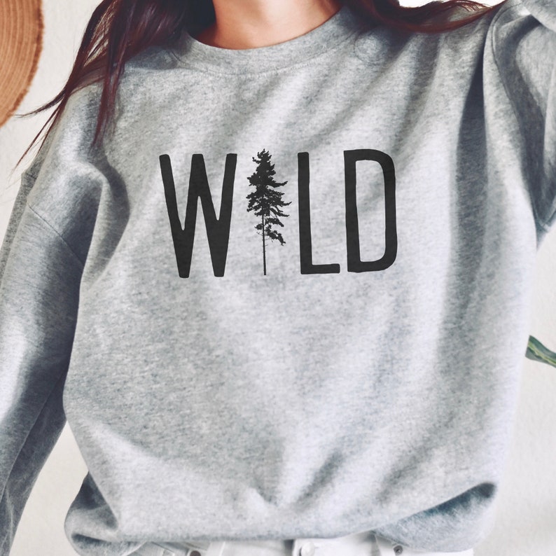 May include: Gray sweatshirt with the word "WILD" printed in black with a stylized pine tree in the middle of the word.