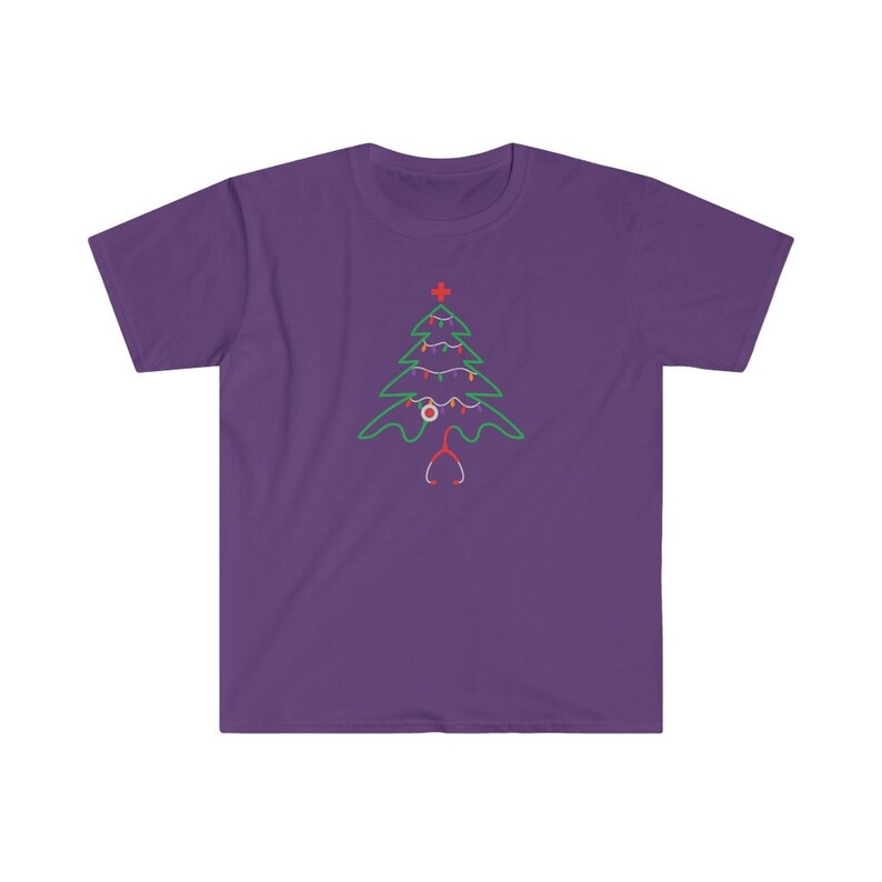 以下が含まれることがあります： 紫色のTシャツに緑色のクリスマスツリーのデザイン。ツリーは赤と白のオーナメントと聴診器で飾られています。