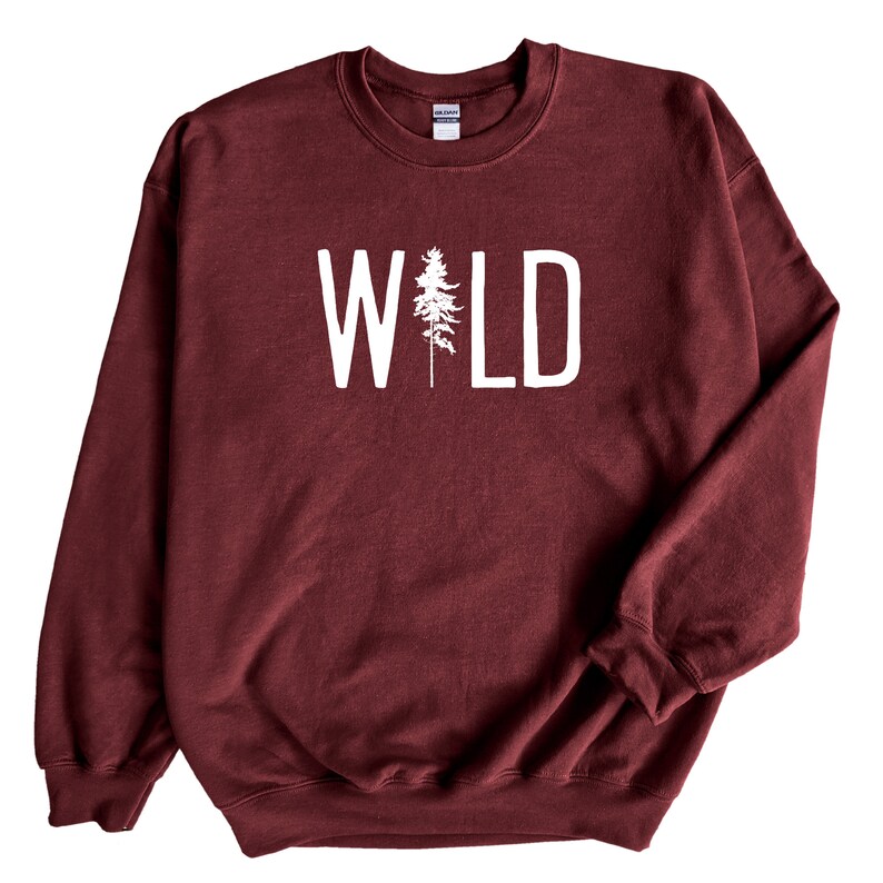 May include: Burgundy sweatshirt with white text that reads "WILD" with a stylized pine tree in the middle of the word.