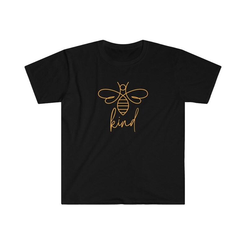 Puede incluir: Camiseta negra con un contorno dorado de una abeja y la palabra "kind" en cursiva. El dise&ntilde;o de la abeja incluye detalles del cuerpo y las alas del insecto. La camiseta tiene cuello redondo y mangas cortas.