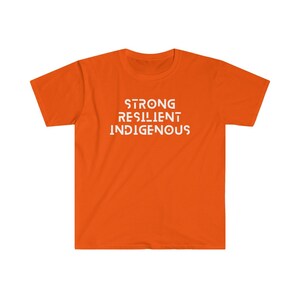 May include: Orange t-shirt with the words "STRONG RESILIENT INDIGENOUS" printed in white.