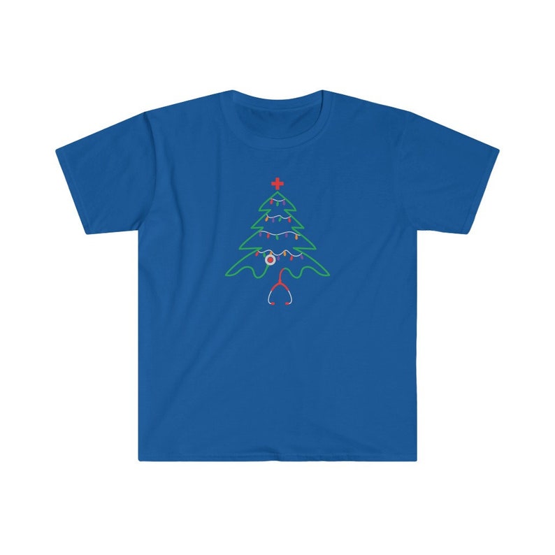 以下が含まれることがあります： 青いTシャツに緑色のクリスマスツリーのデザインが施されています。ツリーは赤と白のオーナメントと聴診器で飾られています。