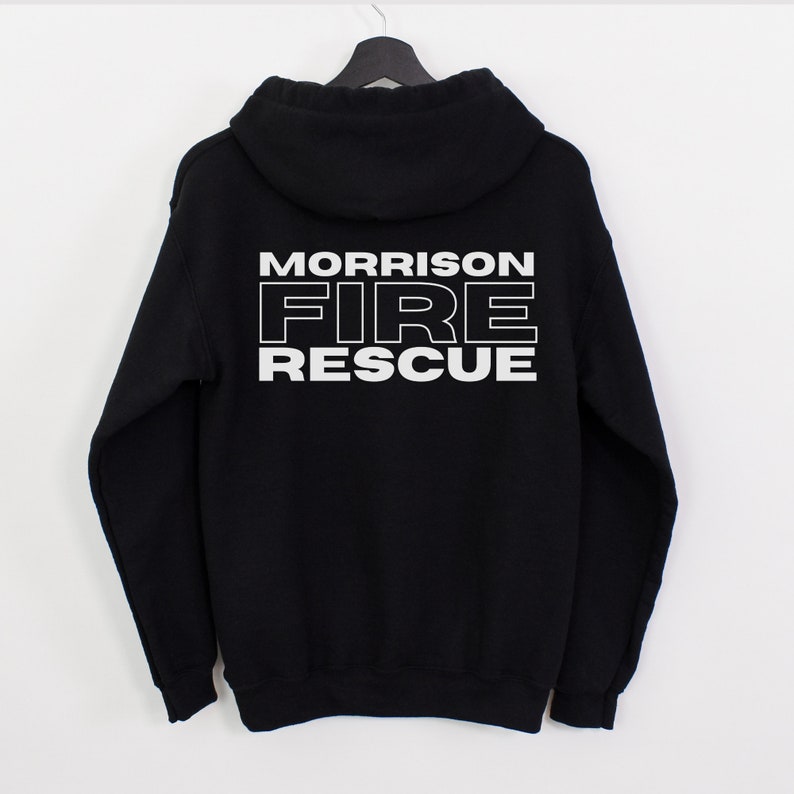 Peut inclure: Sweat-shirt &agrave; capuche noir avec un texte blanc au dos qui dit "MORRISON FIRE RESCUE".