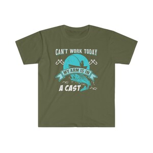 May include: Green t-shirt with the text "Can't work today, my arm is in a cast" and a graphic of a person fishing. The graphic is in blue and white.