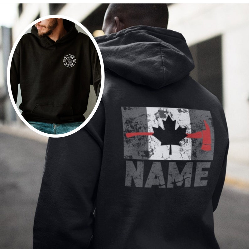Op de afbeelding: Zwart hoodie met een verweerd Canadees vlagontwerp en een rode bijl met een rode lijn over de vlag. De tekst "NAME" staat onder de vlag.