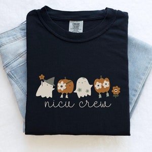 May include: Black t-shirt with a graphic of four ghosts dressed as pumpkins and the text "nicu crew".