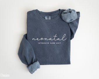 May include: A dark blue sweatshirt with the text "neonatal intensive care unit" in white lettering.