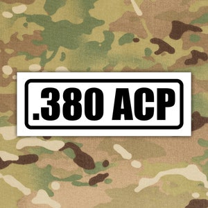 May include: White rectangular sticker with a black border and black text that reads ".380 ACP".