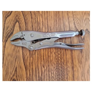 May include: Silver-toned pliers with a black handle. The pliers have a "Vise-Grip" logo and the text "USA" on the handle.