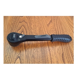 May include: A black ratcheting wrench with a textured black handle and a gray switch. The wrench has the text "1/4" printed on it.