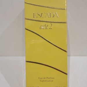 Puede incluir: Caja amarilla con letras doradas para una botella de Escada acte 2 Eau de Parfum Vaporisateur, 1.7 fl oz / 50 ml.