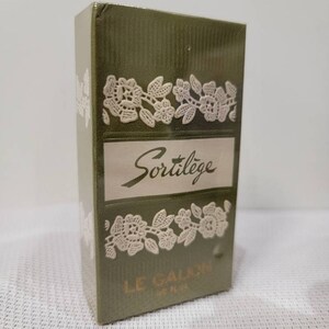 May include: A green box with white lace trim and the words "Sortilège" and "LE GALION PARIS" printed on it.