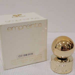 May include: A white box with gold lettering that reads "Courr&egrave;ges Empreinte" and "CTIF EMB 59139". The box is for a perfume bottle with a gold ball stopper.