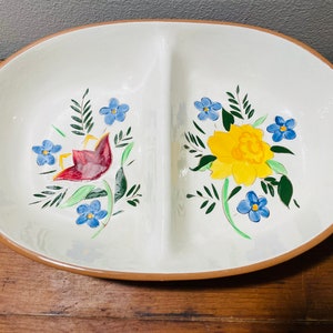 May include: A white divided serving dish with a brown rim. The dish is decorated with hand-painted floral designs featuring red, yellow, and blue flowers.
