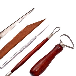 Peut inclure: Ensemble de quatre outils de poterie avec des manches en bois et en m&eacute;tal. Les outils comprennent un outil de sculpture en bois, un outil en boucle m&eacute;tallique, un outil en aiguille m&eacute;tallique et un outil de raclage m&eacute;tallique.