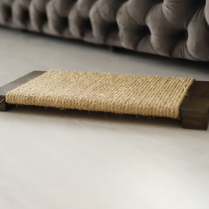May include: A brown wooden cat scratching post with a natural sisal rope surface.