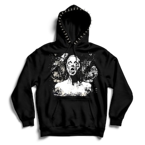 Pode incluir: Moletom preto com um gráfico branco desgastado de uma figura gritando. O capuz é adornado com pontas prateadas. Possui um bolso canguru e cordão.