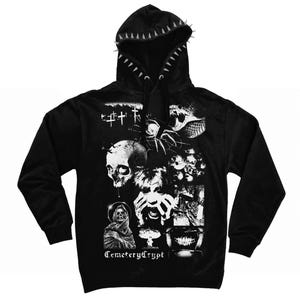 May include: A black hooded sweatshirt featuring a hood lined with silver spikes and black drawstrings. The front displays a white graphic collage of a skull, a spider, a cloaked figure, a screaming face, and the text CemeteryCrypt.
