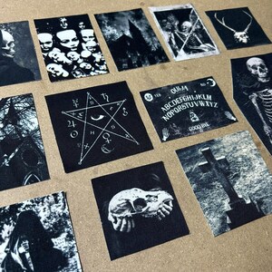 May include: A set of 10 black and white iron-on patches with various gothic and occult themes. The patches feature images of a pentagram, a skull, a Ouija board, a graveyard, and a church.