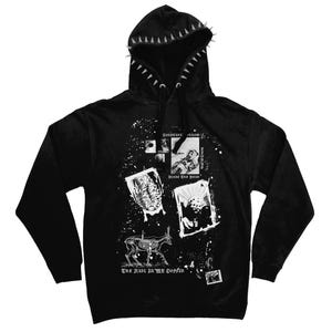 May include: A black hooded sweatshirt featuring a row of silver spikes along the hood edge and black drawstrings. The front displays a white graphic collage with skeletal animal illustrations, framed imagery, and the text "Bless The Dead" and "The Nail In My Coffin".